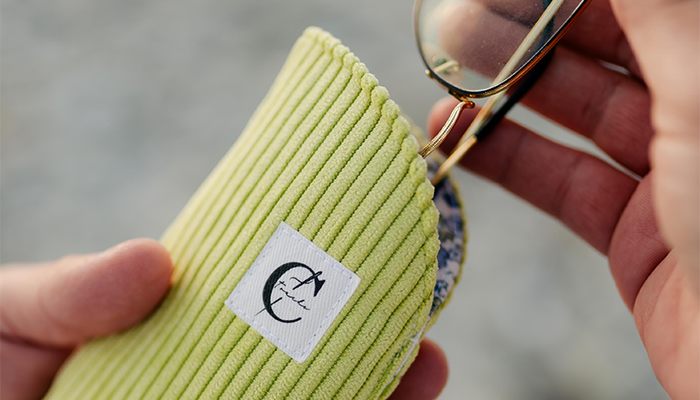 Etui à lunette vert côtelé, avec une pair de lunette rangée à l'intérieur