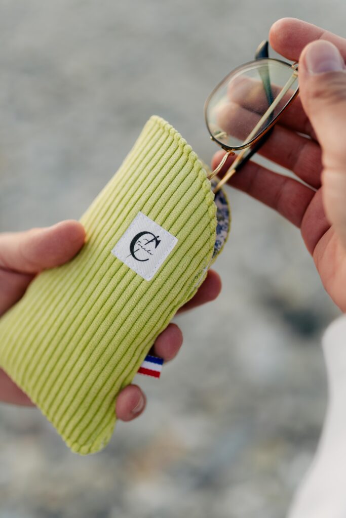 Etui à lunette vert côtelé, avec une pair de lunette rangée à l'intérieur